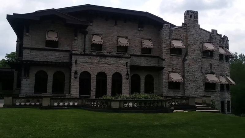 The Henry Ford Estate (Fair Lane) Featuring a Large Stone Mansion with Arched Windows and A Grassy Front Yard