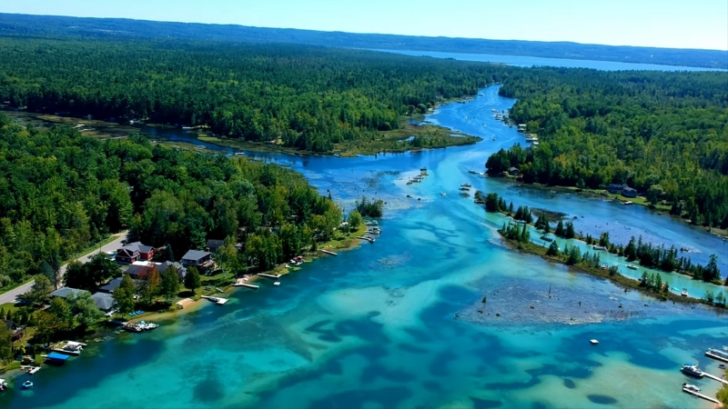 An Aerial View of Torch Lake, Surrounded by Lush Greenery and Boats Along Its Shoreline