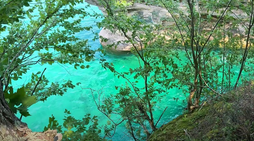 Emerald-hued water, framed by lush green foliage